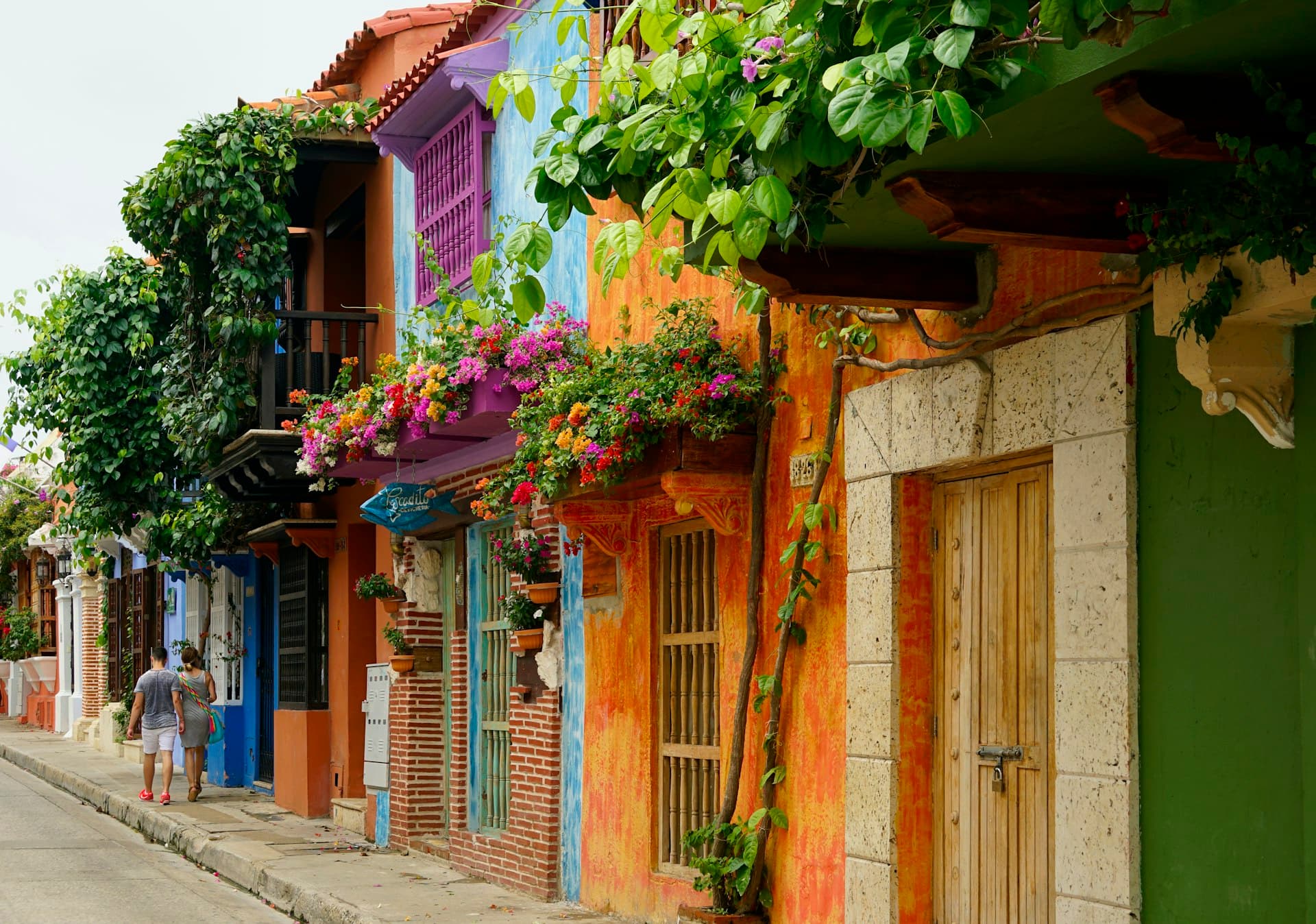 Colourful colonial buildings with flower-draped balconies on a street in Cartagena, Colombia
