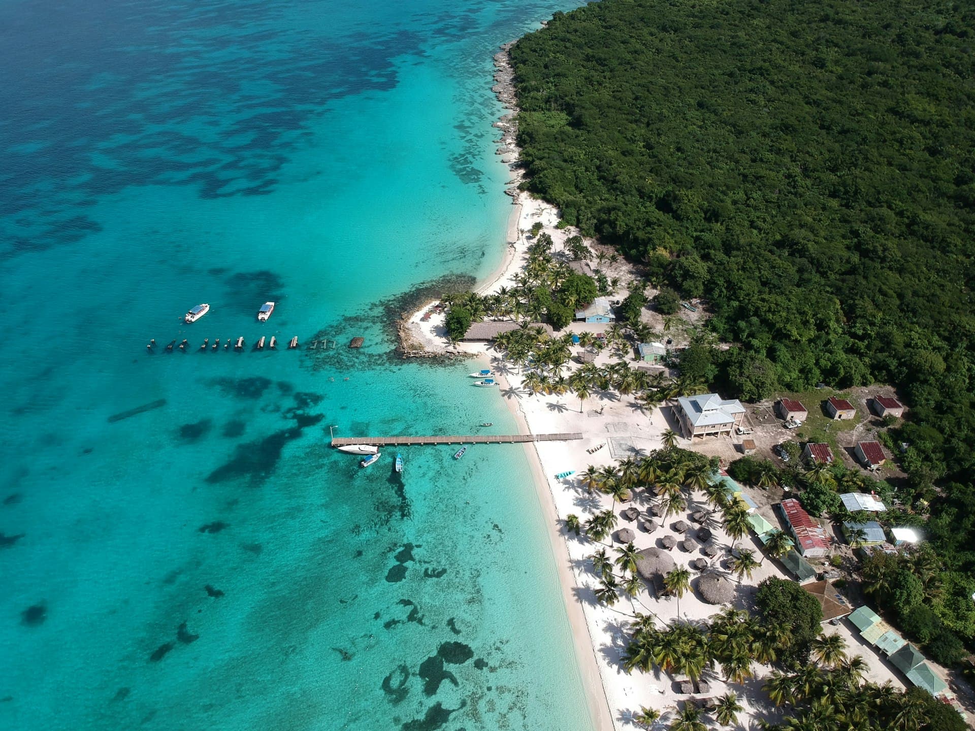 Aerial view of a tropical island with white sand beach, palm trees and turquoise waters in the Dominican Republic