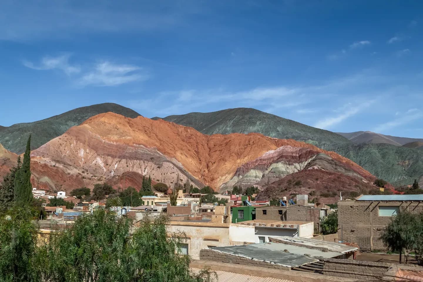 The striped Hill of Seven Colours behind the rooftops of Purmamarca, Jujuy, Argentina