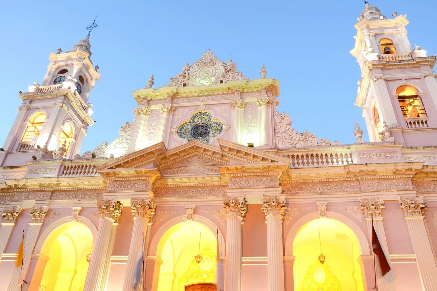 A pink church facade lit up at dusk in the centre of Salta, Argentina