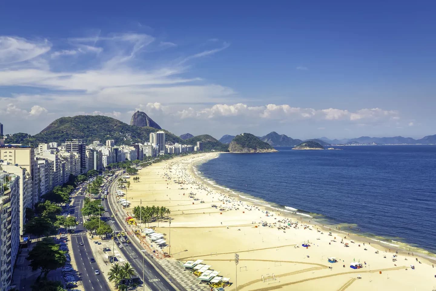 Aerial view of Copacabana beach curving along the coast with Sugarloaf Mountain in the distance, Rio de Janeiro, Brazil