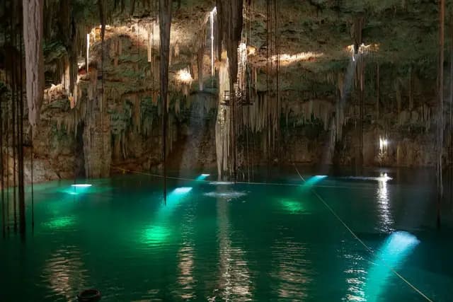 Crystal-clear turquoise cenote surrounded by limestone walls in the Yucatan