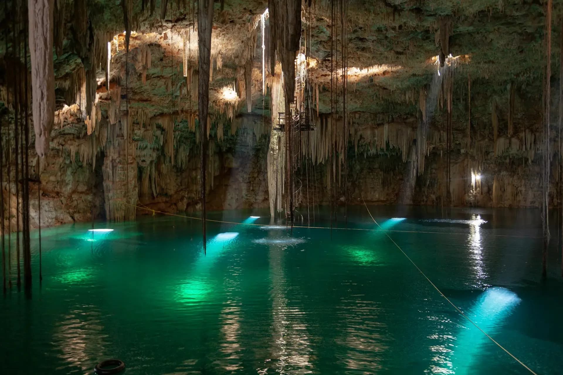 Crystal-clear turquoise cenote surrounded by limestone walls in the Yucatan