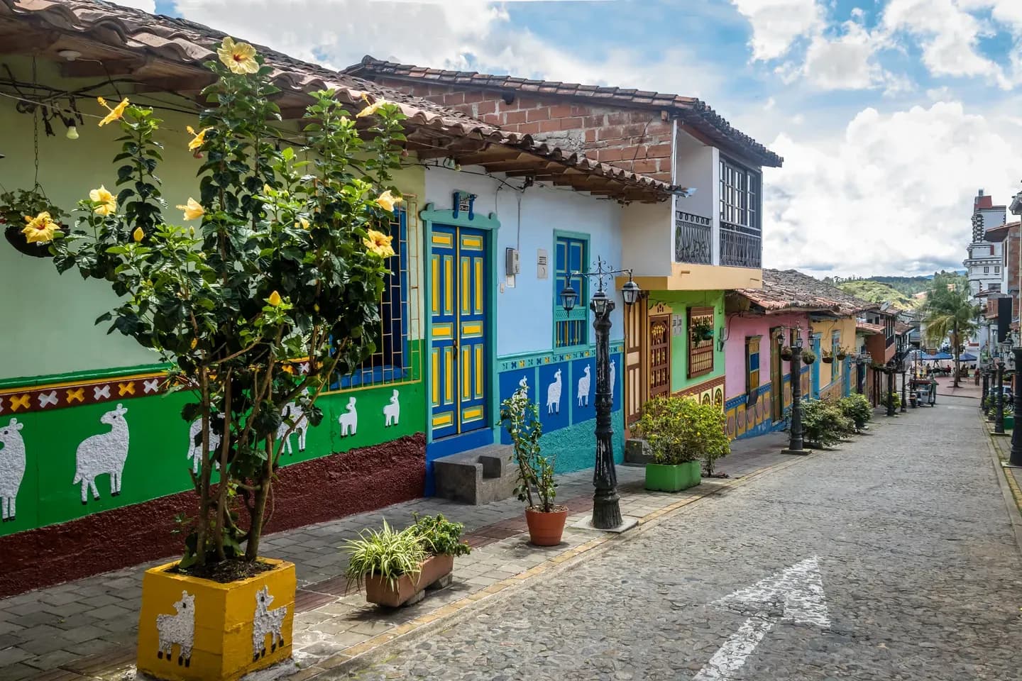 Colourful houses with painted zócalo panels along a cobblestone street in Guatapé, Antioquia, Colombia