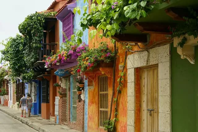 Colourful colonial buildings with flower-draped balconies on a street in Cartagena, Colombia