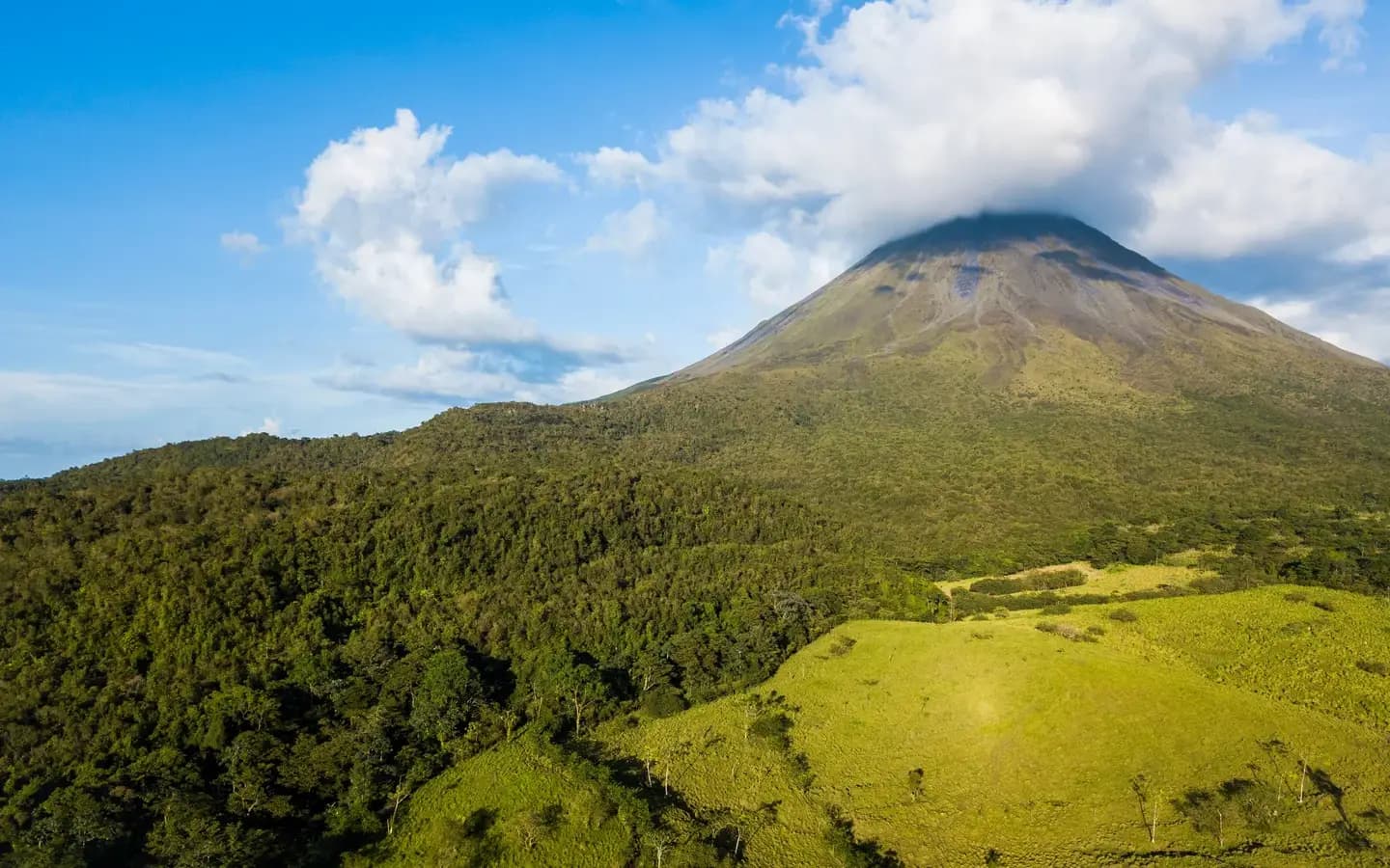 The cone of Arenal Volcano rising above green foothills and rainforest, Costa Rica