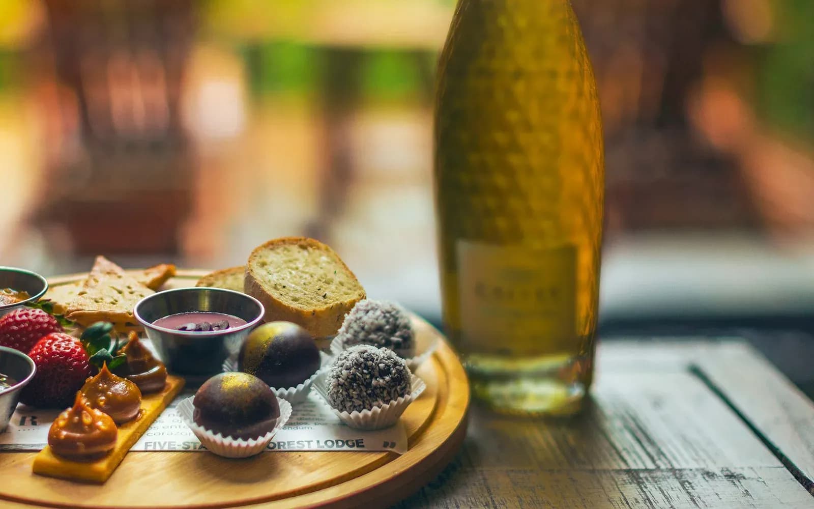Sparkling wine, chocolates and strawberries set out on a board at Amor Arenal