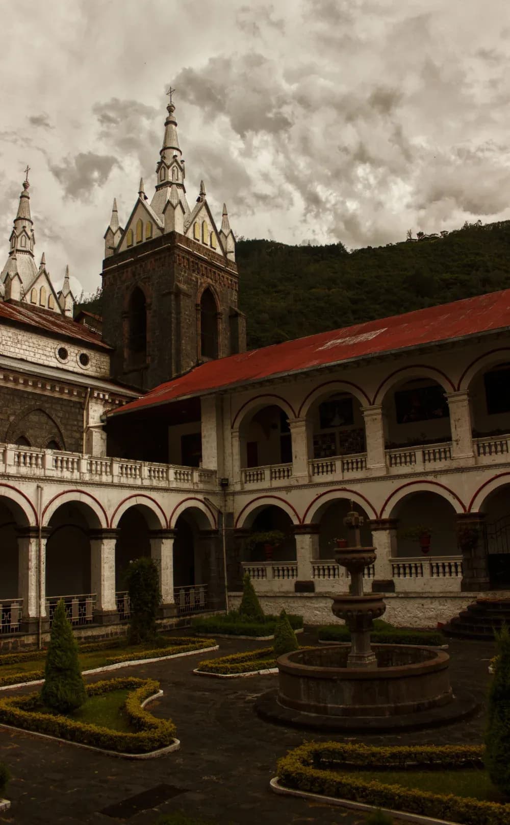 The stone towers and arched cloister of the basilica of the Virgin of the Holy Water, Baños, Ecuador