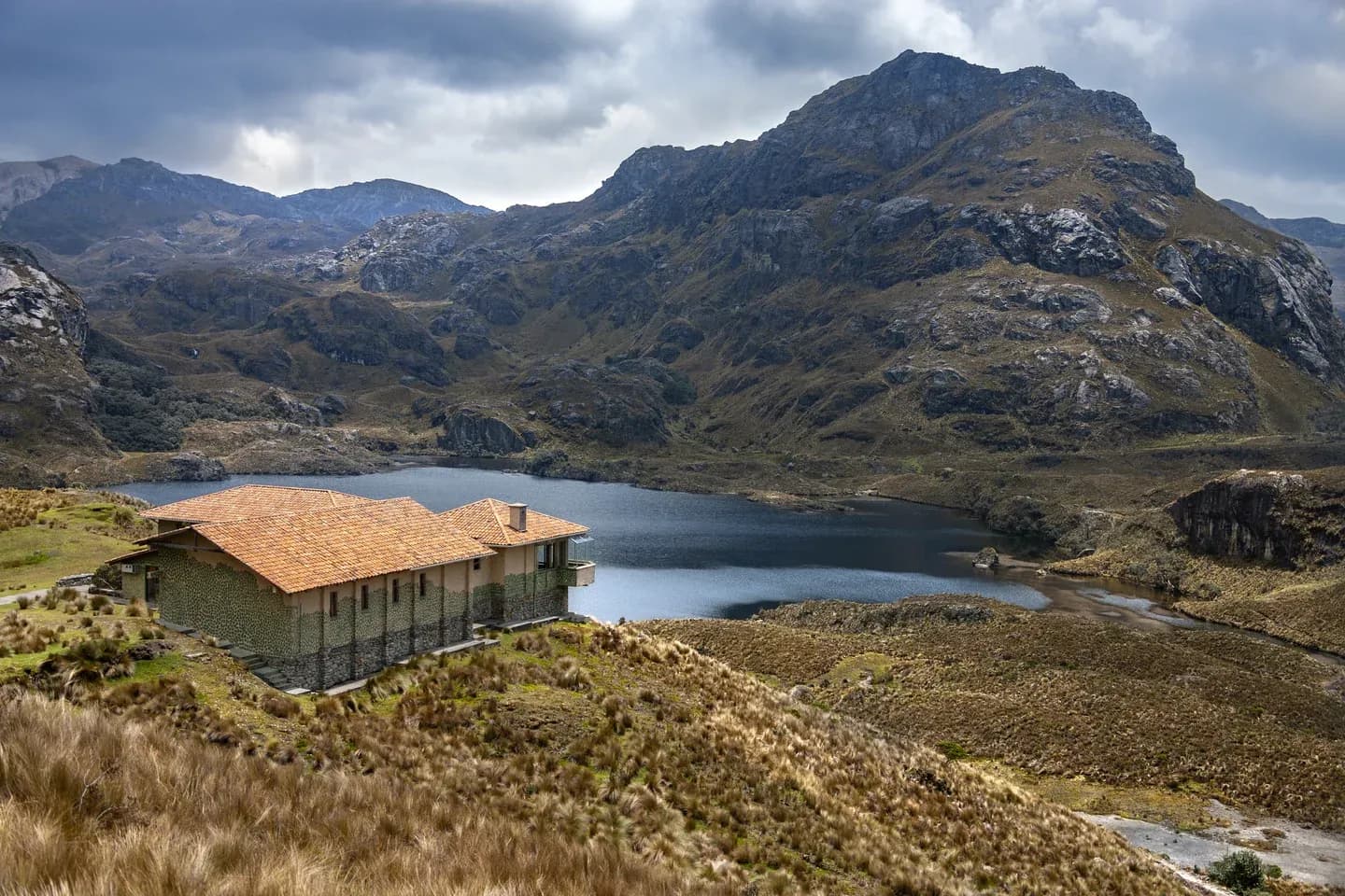 A stone refuge above a lake among the páramo peaks of Cajas National Park, Ecuador