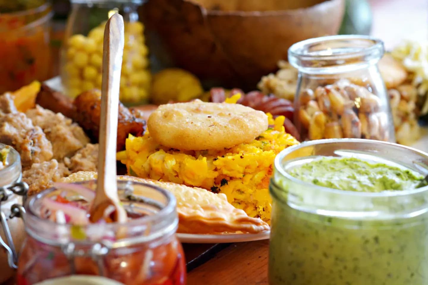 Ecuadorian plantain dishes with salsas and pickles on a table
