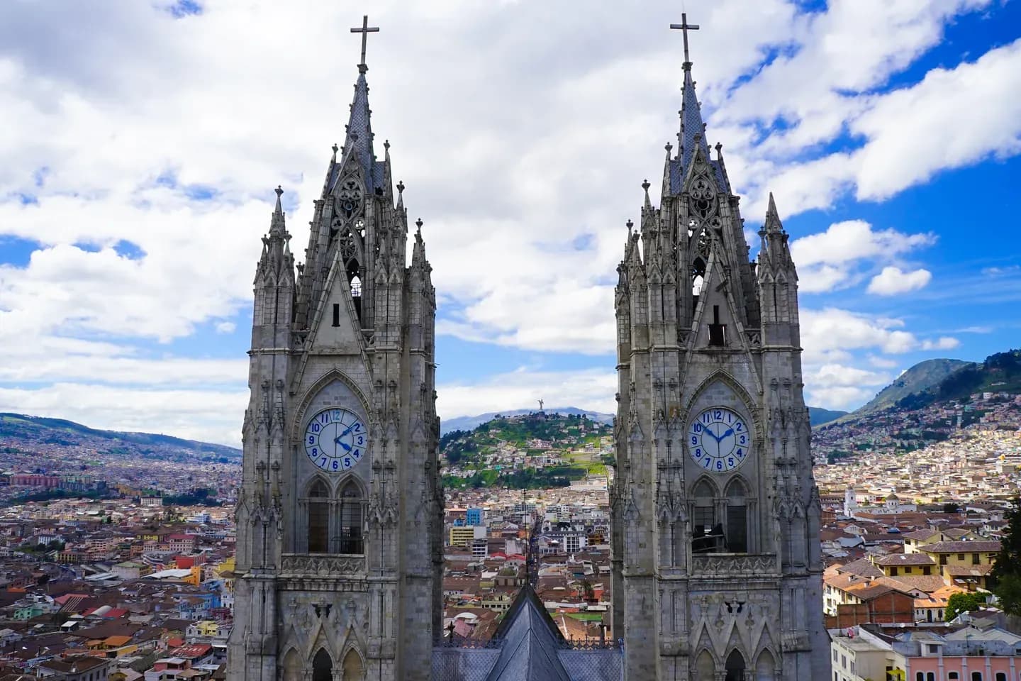 The two Gothic clock towers of the Basilica del Voto Nacional above the rooftops of Quito, Ecuador