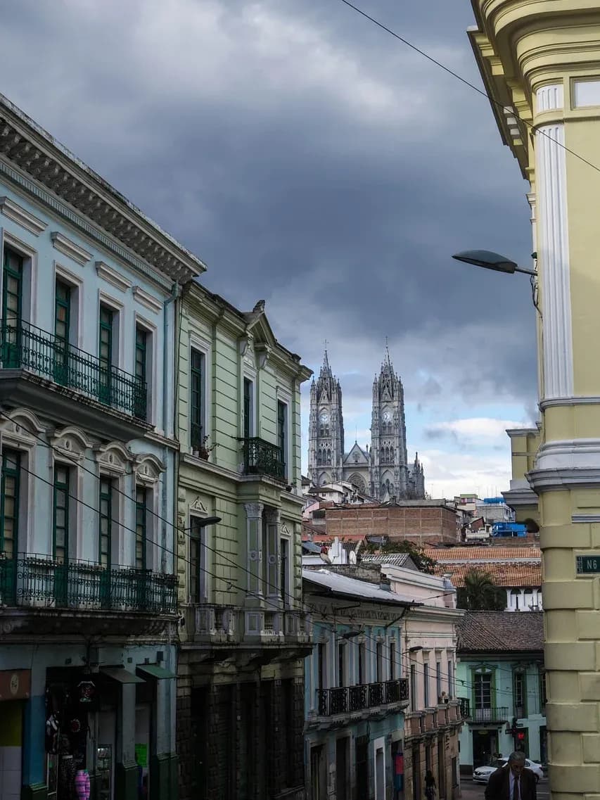 Colonial facades in Quito's old town with the towers of the Basílica del Voto Nacional behind, Ecuador