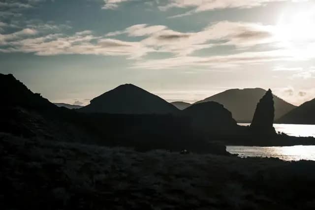 Pinnacle Rock on Bartolome Island silhouetted against a dramatic sunset in the Galapagos Islands