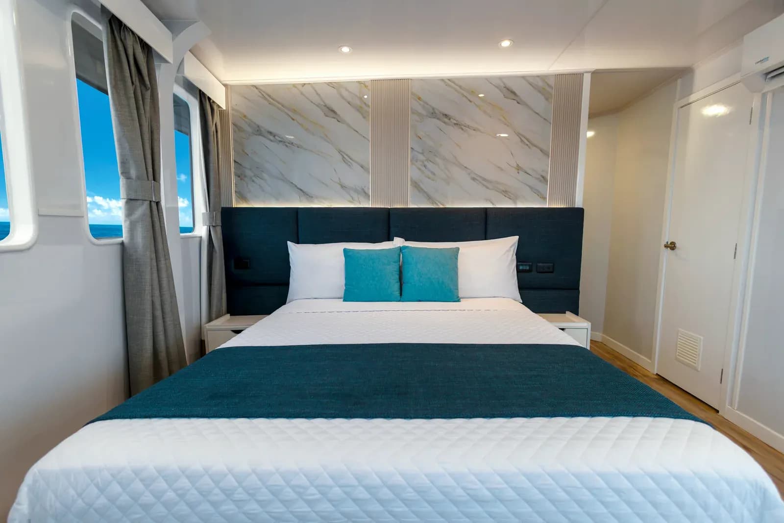 Double cabin with curtained windows and a wardrobe unit aboard Galaxy Diver II, Galápagos