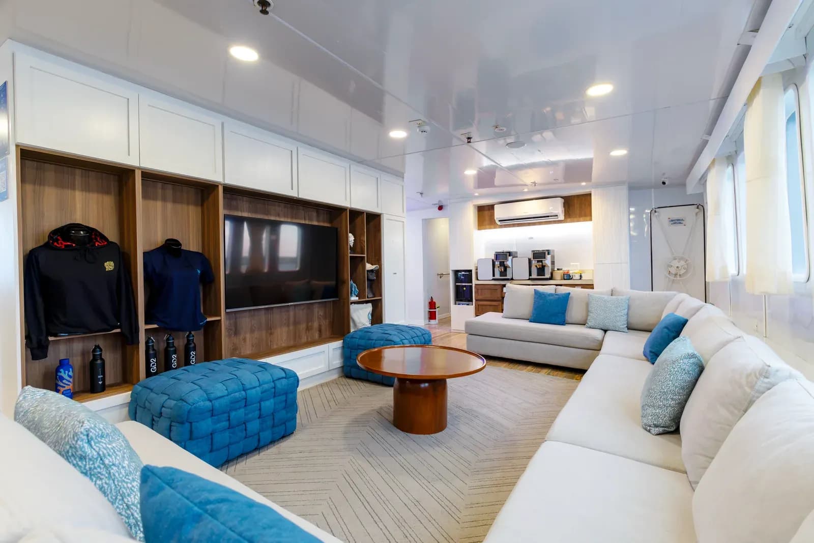 Lounge with an L-shaped sofa and a wall-mounted TV aboard Galaxy Diver II, Galápagos