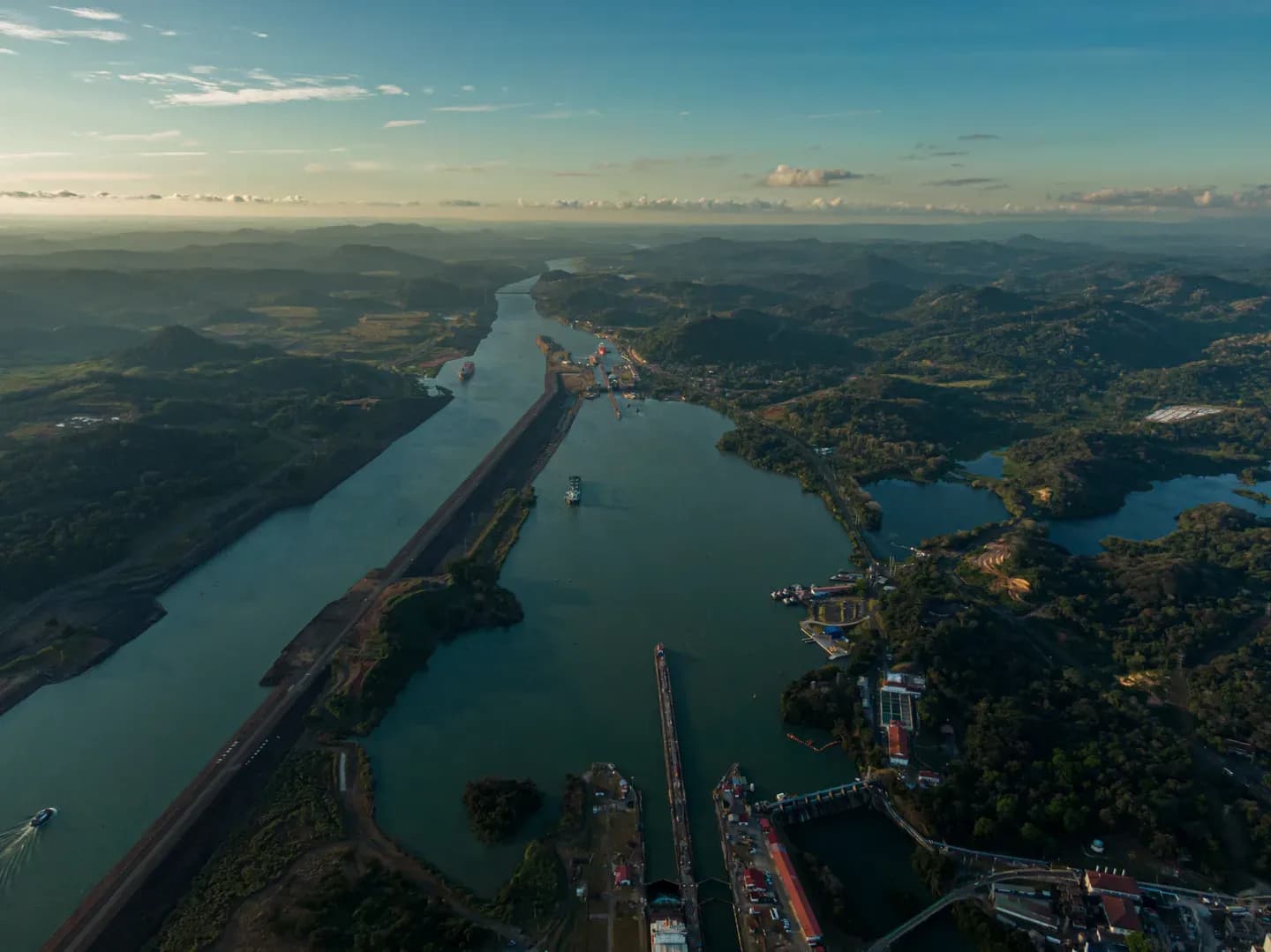 The Panama Canal winding through green hills past the Miraflores Locks, seen from the air