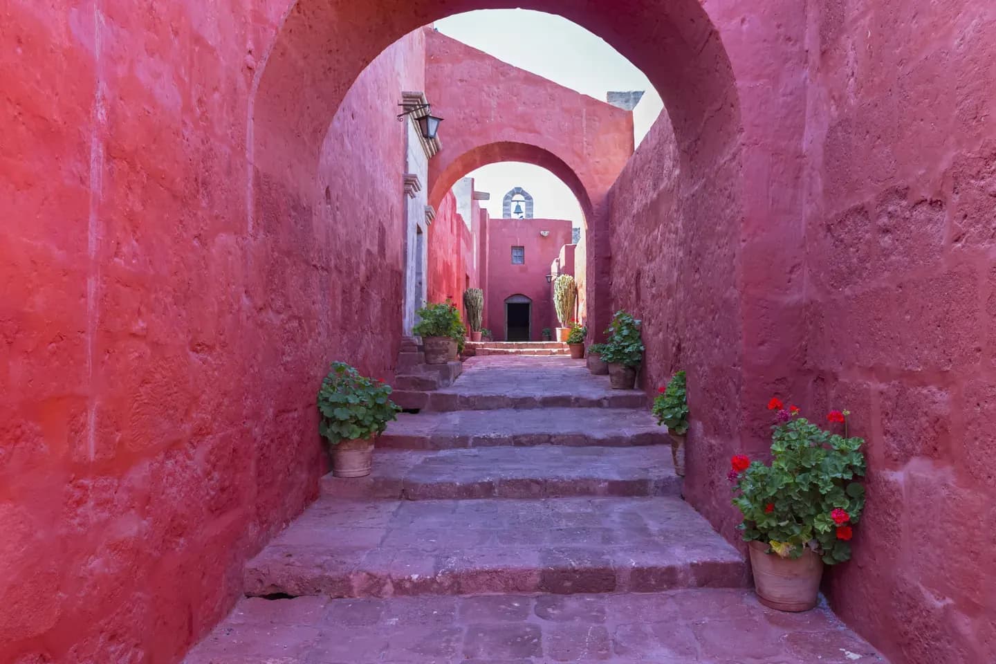 A red-walled alley with flower pots inside the Santa Catalina monastery, Arequipa, Peru