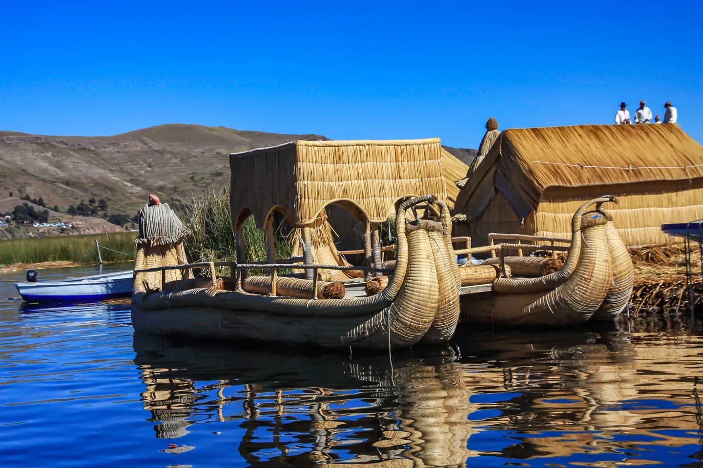 Totora reed boats and reed houses on one of the Uros floating islands, Lake Titicaca, Peru