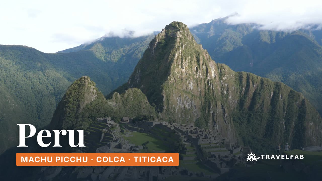Machu Picchu below the peak of Huayna Picchu, with cloud on the mountains behind