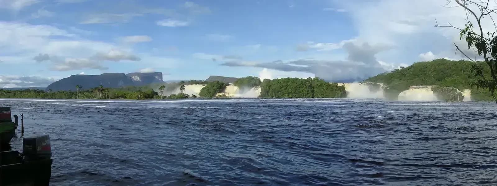 Canaima Lagoon with pink-tinged waterfalls cascading into turquoise waters in Canaima National Park, Venezuela