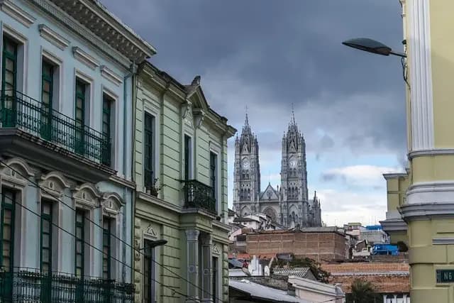 Colonial facades in Quito's old town with the towers of the Basílica del Voto Nacional behind, Ecuador