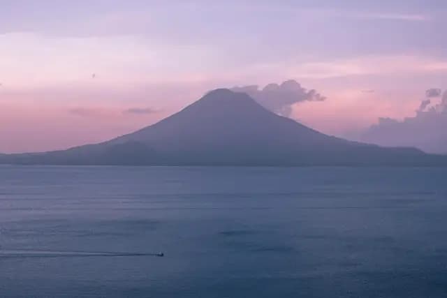 Lake Atitlan at sunset framed by volcanic peaks in Guatemala