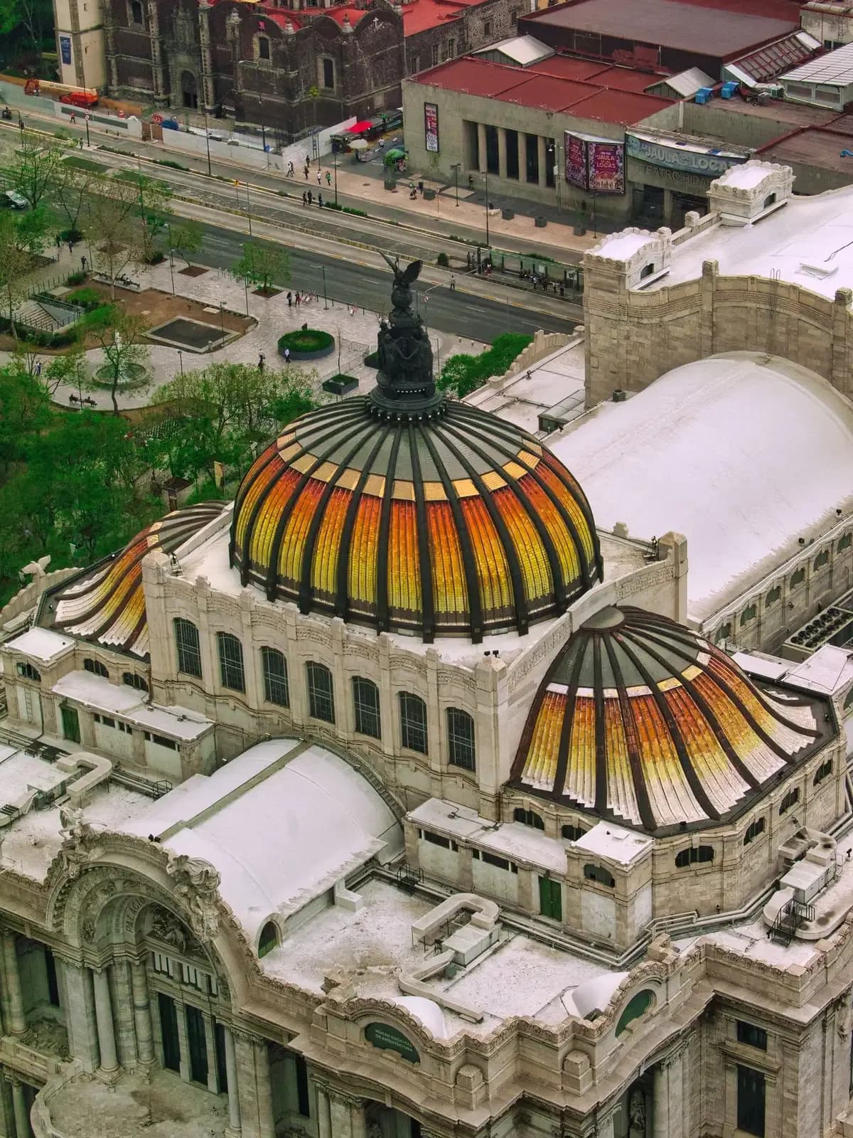 The amber and gold tiled domes of the Palacio de Bellas Artes seen from above, Mexico City